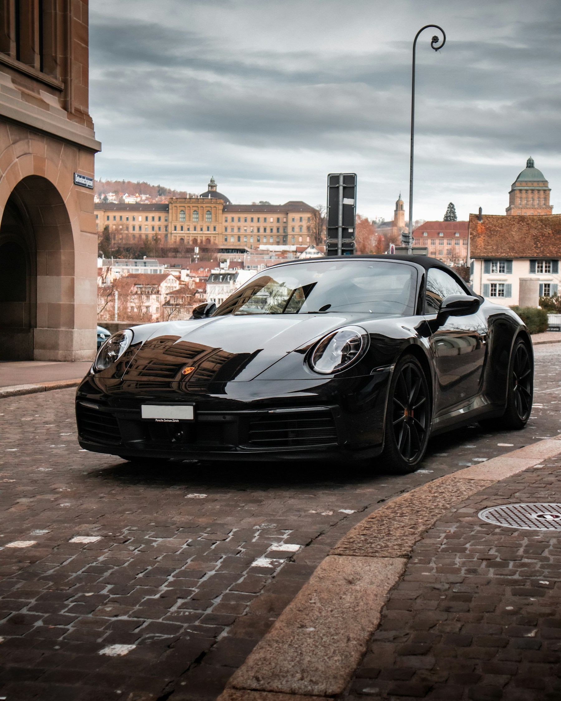 Black Porsche outside historic architecture